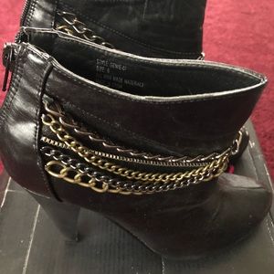 Twisted black boots with gold and silver chains